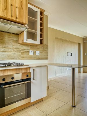 Bright and clean kitchen interior with wood cabinets and a gas stove in a Pretoria residence.